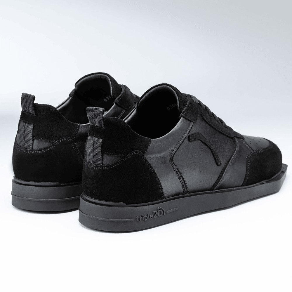 20100006-00_Triple20_Dartschuhe_Leder_Schwarz_3 Das Bild zeigt ein Paar schwarze Lederschuhe der Marke Triple20 Dartschuhe. Die Schuhe haben eine sportliche Optik mit auffälligen Nähten und einer stabilen Sohle.