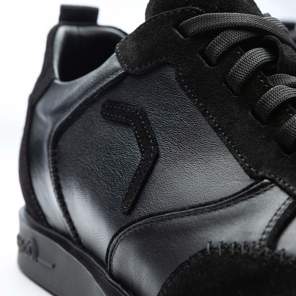 20100006-00_Triple20_Dartschuhe_Leder_Schwarz_5 Der Schuh „Triple20 Dartschuhe Leder - Schwarz“ ist aus schwarzem Leder gefertigt und hat schwarze Schnürsenkel. Die Nahaufnahme zeigt die hochwertige Verarbeitung und das dezente Design.