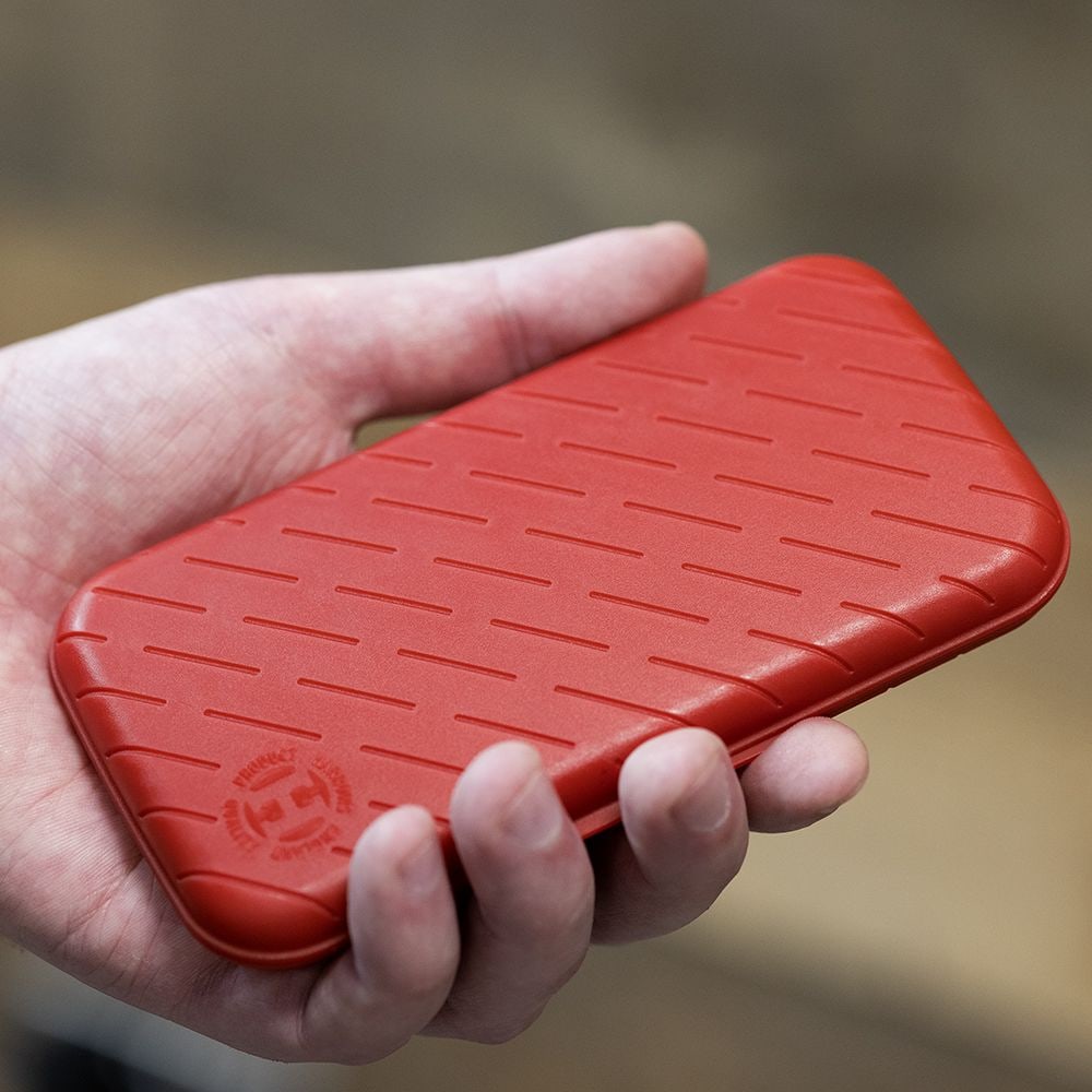 Custodia per freccette Harrows Slimcase Eine Person hält eine rote, strukturierte Darttasche in der Hand. Die Darttasche hat eine schlanke und kompakte Form.