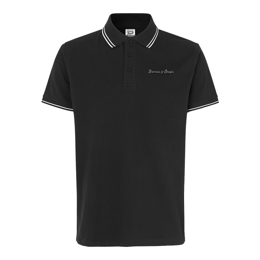 Polo Barrels and Shafts - Nera Das Bild zeigt ein schwarzes Poloshirt mit weißen Akzenten an Kragen und Ärmeln. Auf der Brust ist der Schriftzug "Barrels & Shafts" eingestickt.