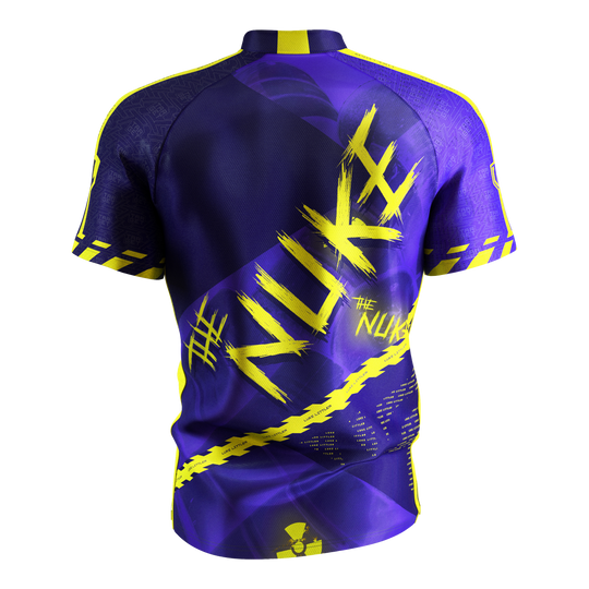 Maglietta da freccette Target Coolplay Luke Littler 2025 Das Bild zeigt das „Target Coolplay Luke Littler 2025 Dartshirt“ von hinten. Das Shirt ist überwiegend lila mit auffälligen gelben Designs und dem Schriftzug „NUKE“ auf dem Rücken.
