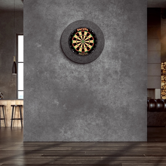 Cornice per bersaglio in acciaio Karella Ultimo An der Wand hängt ein "Karella Ultimo Steeldartboard Surround". Der Raum wirkt modern und stilvoll mit dunklen Farben und eleganter Einrichtung.