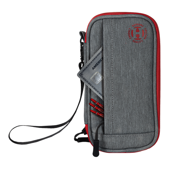 Portafoglio Smart Case Harrows Das Bild zeigt ein graues und rotes Dart-Etui mit einem Reißverschluss und einer Handschlaufe. In der Vordertasche stecken eine Kreditkarte und einige Dartspitzen.