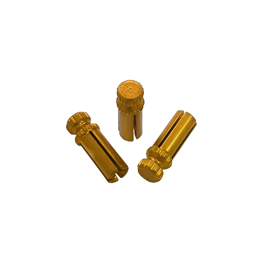 Das Bild zeigt drei goldfarbene Alu Flightschoner. Sie sind kleine, zylindrische Schutzkappen für Dart-Flights.