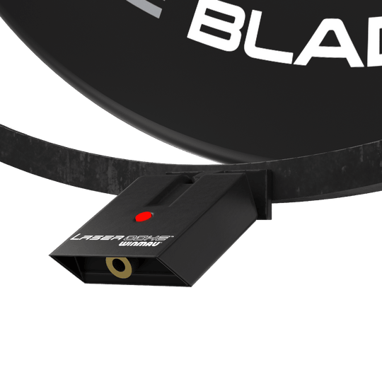 Set di accessori al plasma Winmau Das Bild zeigt das Winmau Plasma Zubehör Set, das an einem Dartboard befestigt ist. Sichtbar ist ein schwarzes Gerät mit der Aufschrift "Laser Oche Winmau" und einem roten Knopf.