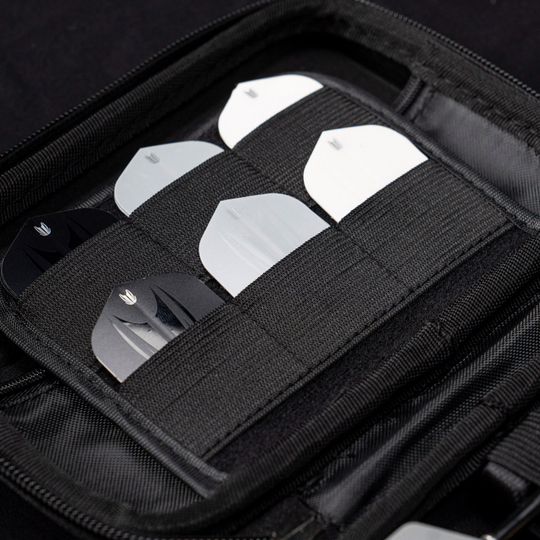 Custodia per freccette Takoma XL Ghost Series Luke Littler Das Bild zeigt das „Target Takoma Bolide XL Dartcase“, das mehrere Dart-Flights in schwarzen und weißen Farben organisiert aufbewahrt. Die Flights sind sicher in elastischen Halterungen im Inneren des schwarzen Etuis verstaut.