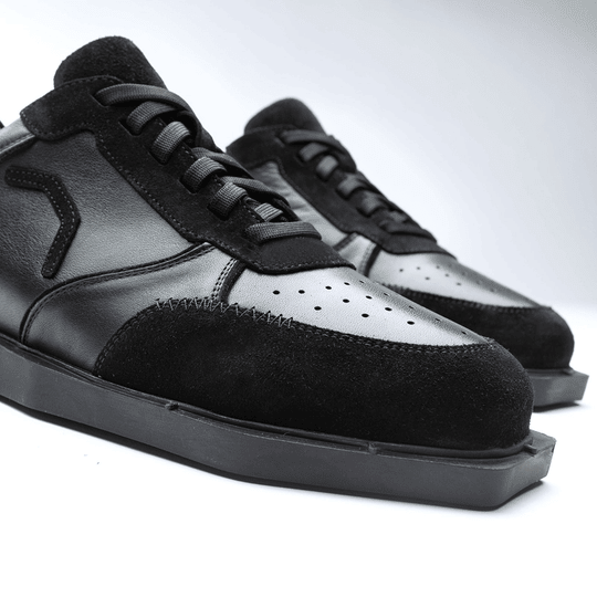 20100006-00_Triple20_Dartschuhe_Leder_Schwarz_4 Auf dem Bild sind schwarze Lederschuhe namens "Triple20 Dartschuhe Leder - Schwarz" zu sehen. Die Schuhe haben eine sportliche Form und bestehen aus einer Kombination von Glattleder und Wildleder.