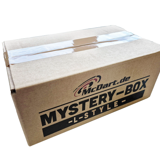 Scatola misteriosa McDart - Stile L Auf dem Bild ist ein brauner Karton mit der Aufschrift „McDart.de MYSTERY-BOX -L-STYLE-“ zu sehen. Die Box ist mit Klebeband verschlossen.