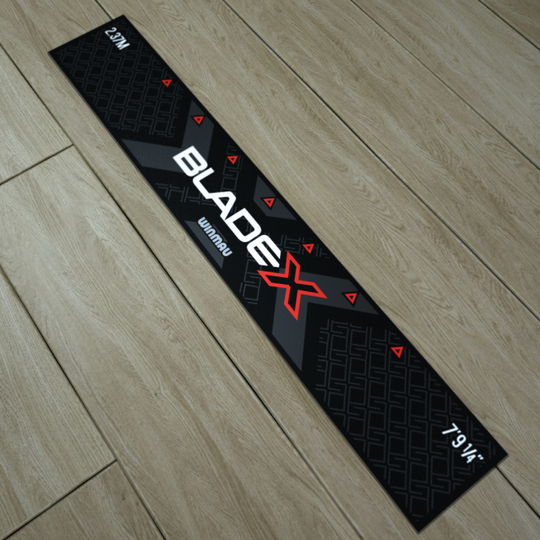 Linea di lancio Winmau Blade X Zu sehen ist die Winmau Blade X Abwurflinie. Sie hilft, die richtige Entfernung beim Werfen festzulegen.