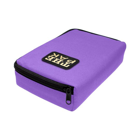 708TP_The_Pak_Dartcase_Violett_2 Das Bild zeigt ein lila Etui mit Reißverschluss, das "The Pak Dartcase" heißt. Auf der Oberseite befindet sich ein schwarzes Label mit weißer Schrift.