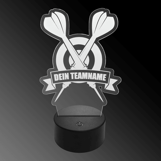 Lampada a freccia a LED in plexiglass con testo personalizzato Das Bild zeigt eine LED-Lampe aus Plexiglas in Form von zwei gekreuzten Dartpfeilen vor einer Zielscheibe. Auf einem Banner steht der Text "DEIN TEAMNAME".